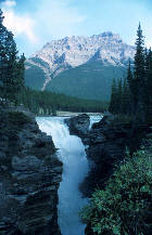 a waterfall near a mountains